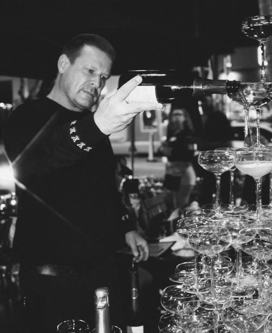 Alexander Ringleb pouring the top of a champagne tower during an evening service