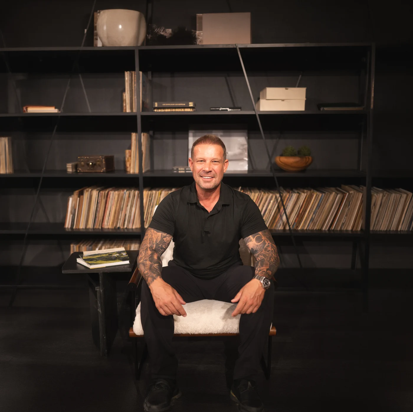 Alexander Ringleb seated in a black shirt in front of shelves of records